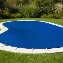 Cobertor azul para piscina redonda instalado sobre el agua, imagen de categor&iacute;a cobertores